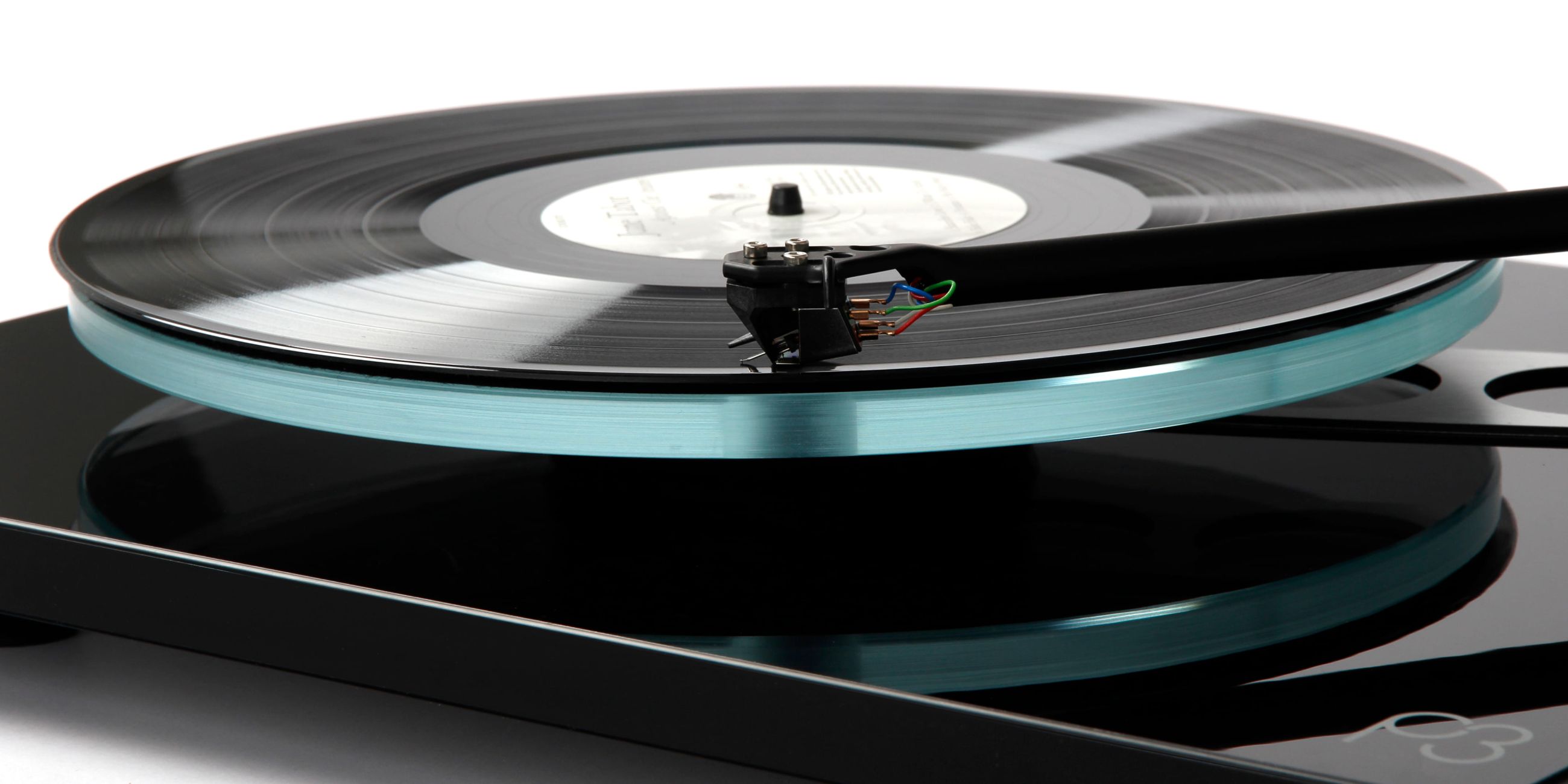 Planar 3 turntable in gloss black finish on a wooden shelf with vinyl records